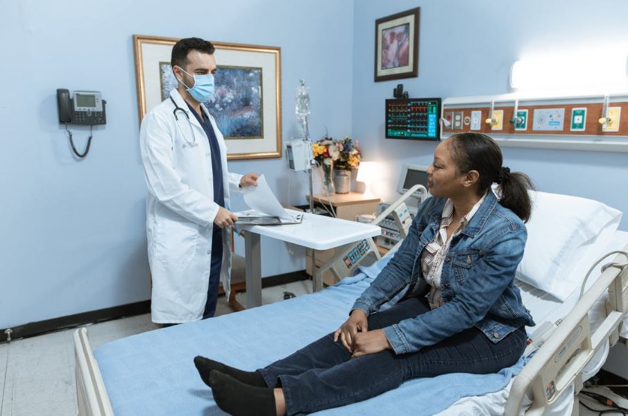 a woman in a hospital bed getting checked by her doctor