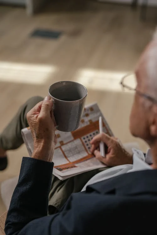 Photograph of an elderly man holding a cup