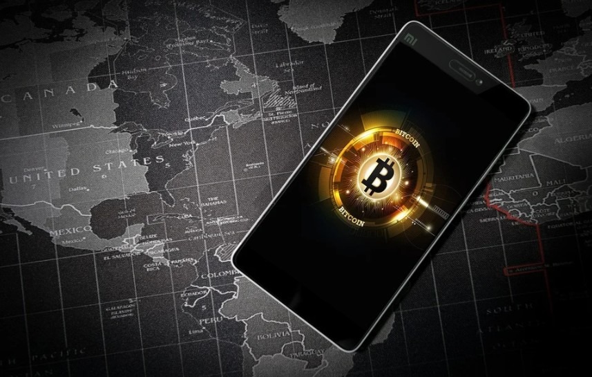 Bitcoin global virtual money in a cell phone over a world map