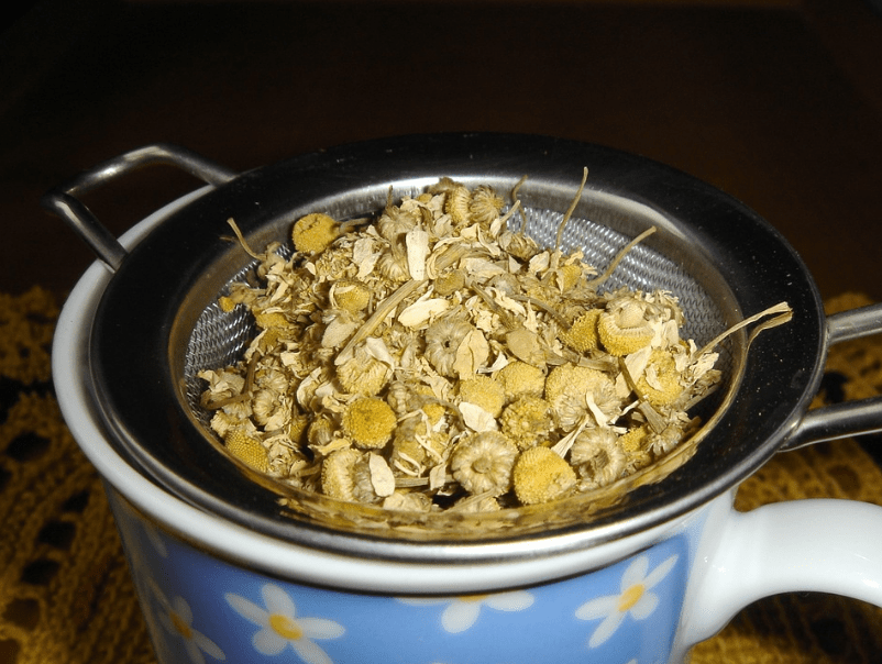 dried chamomile flowers, teapot, strainer