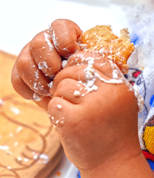 sticky white icing, brown bread, baby holding a bread