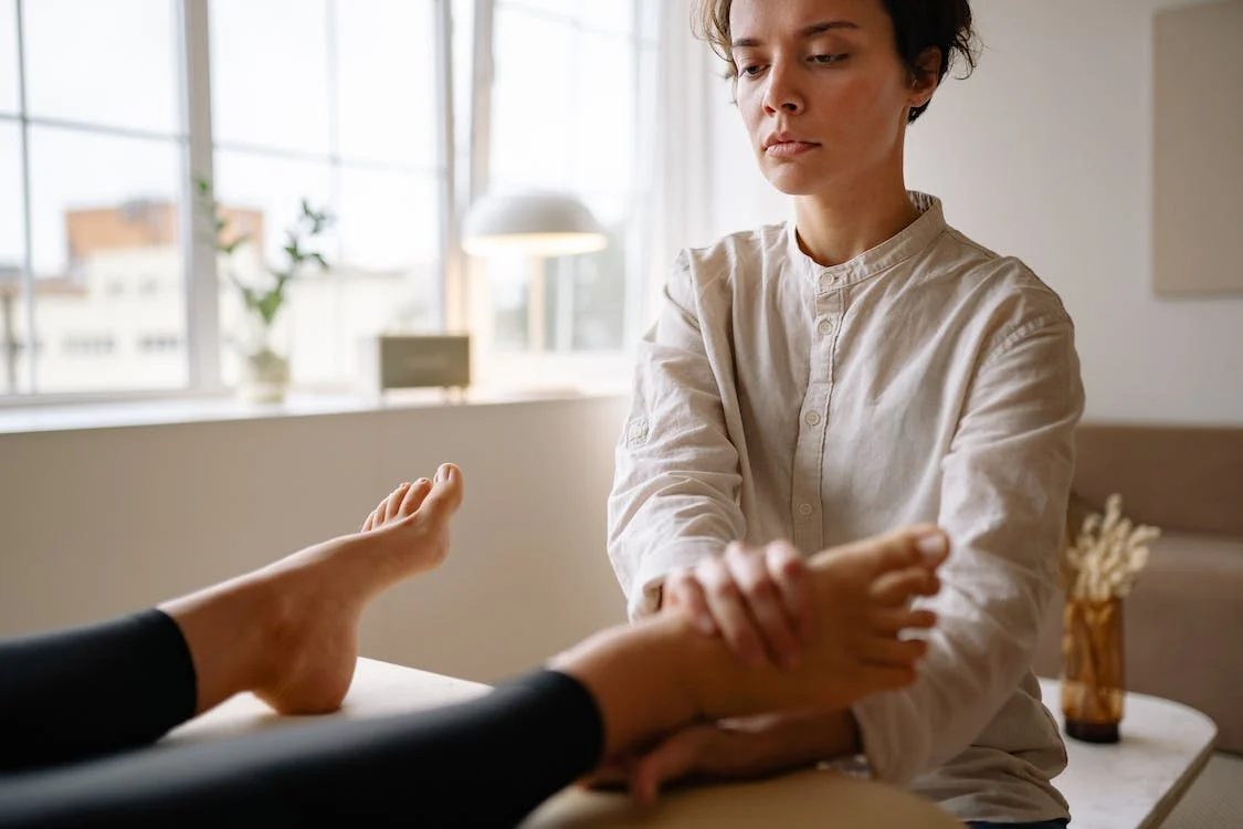 A woman massaging a client’s foot