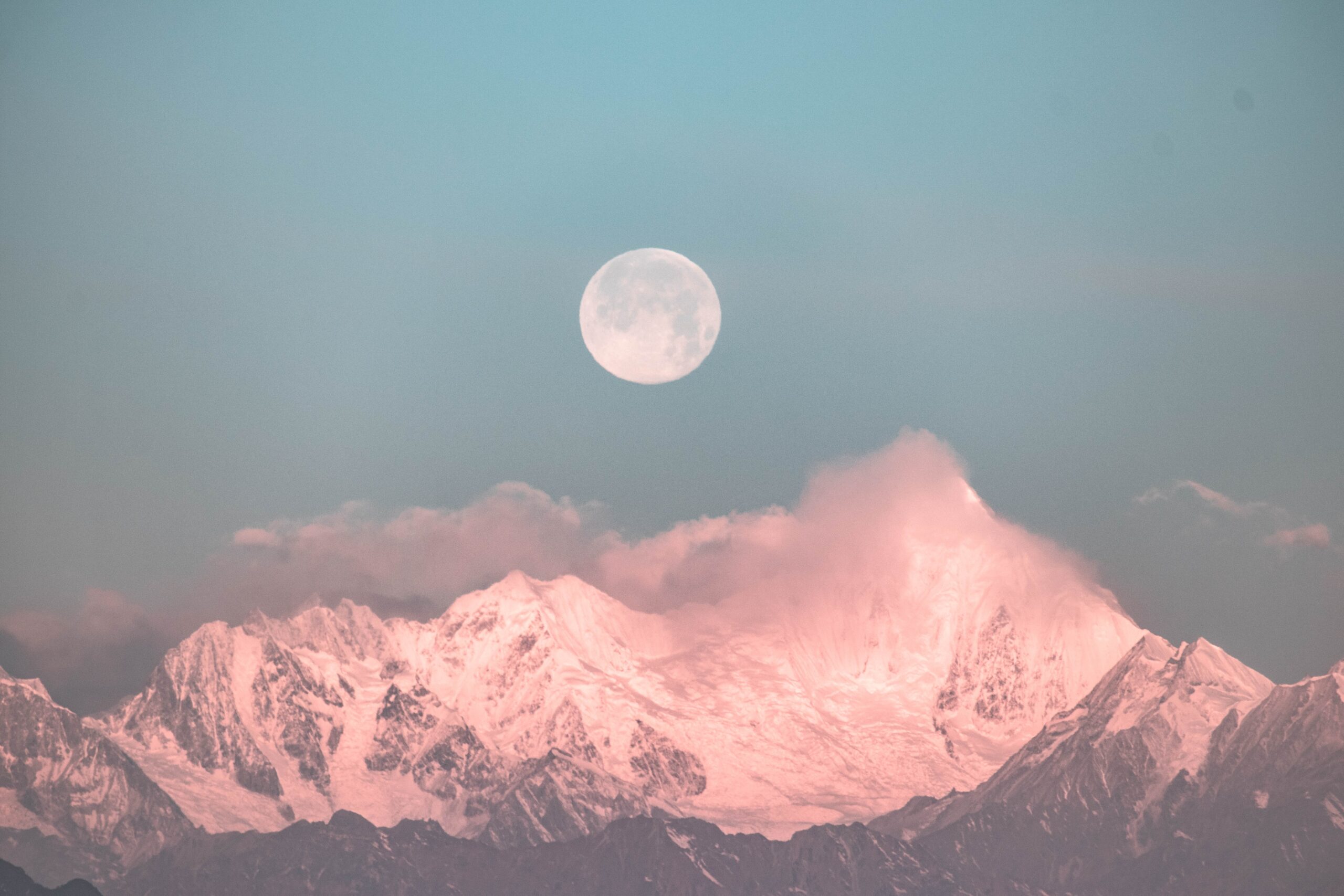 Moon over snow-capped mountain